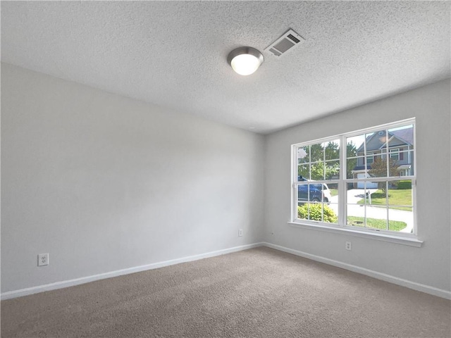 carpeted empty room with a textured ceiling