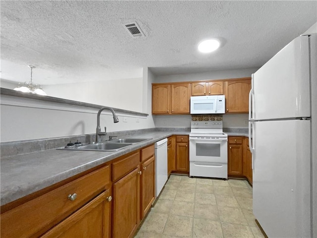 kitchen featuring a textured ceiling, sink, white appliances, and an inviting chandelier