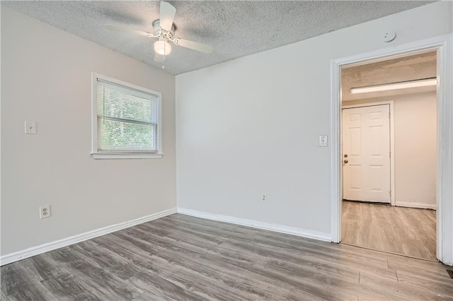 spare room featuring ceiling fan, a textured ceiling, and light wood-type flooring