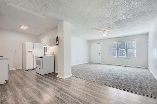 unfurnished living room featuring ceiling fan, light hardwood / wood-style flooring, and a textured ceiling