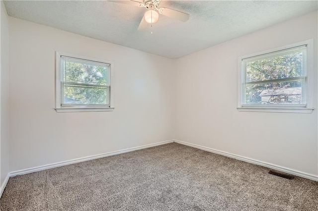 carpeted spare room featuring ceiling fan and a textured ceiling