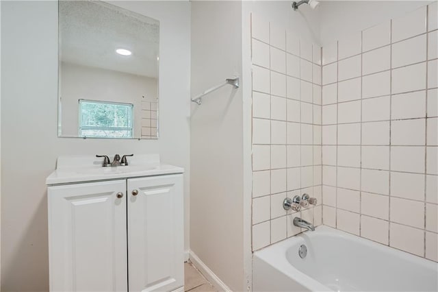 bathroom featuring tiled shower / bath and vanity