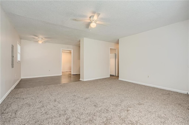 carpeted spare room featuring a textured ceiling and ceiling fan