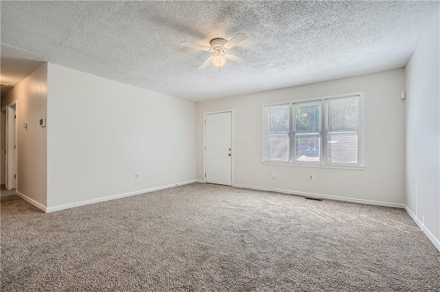 empty room featuring a textured ceiling, carpet floors, and ceiling fan