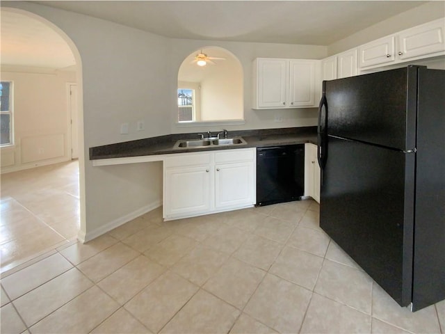 kitchen featuring light tile patterned floors, a sink, white cabinetry, black appliances, and dark countertops