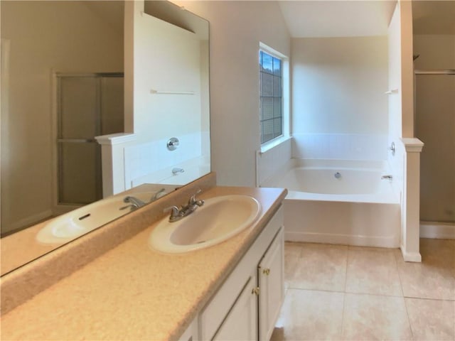 full bathroom featuring lofted ceiling, a garden tub, vanity, a shower stall, and tile patterned floors