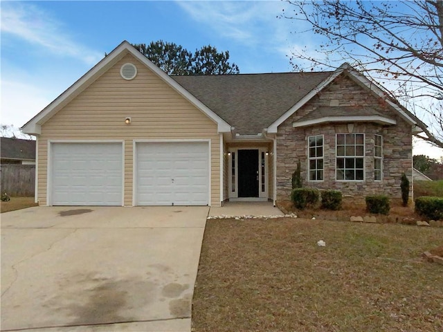 view of front of home featuring a garage, concrete driveway, a shingled roof, and stone siding