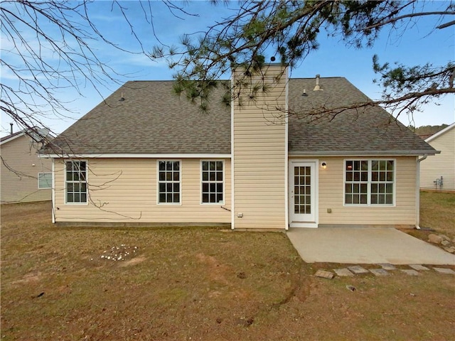 back of house with a patio, a yard, and roof with shingles