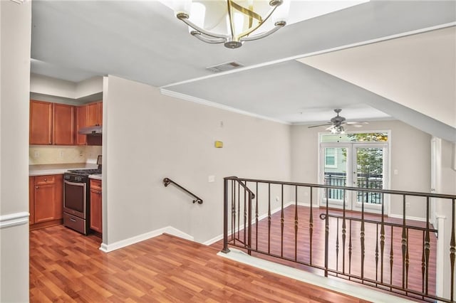 stairs featuring hardwood / wood-style flooring and ceiling fan