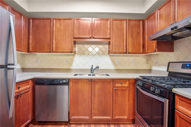 kitchen with sink, light wood-type flooring, stainless steel appliances, and tasteful backsplash