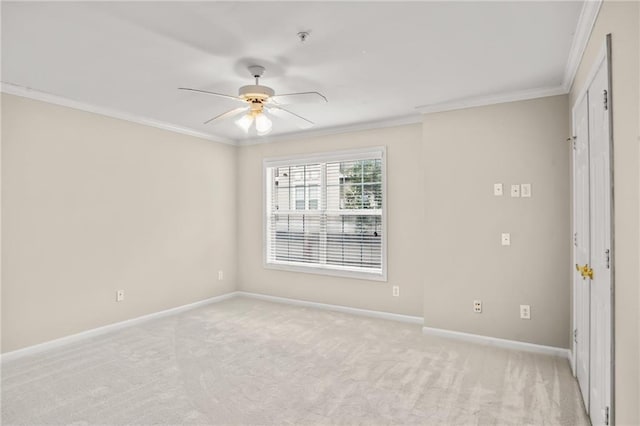 empty room featuring crown molding, ceiling fan, and light carpet