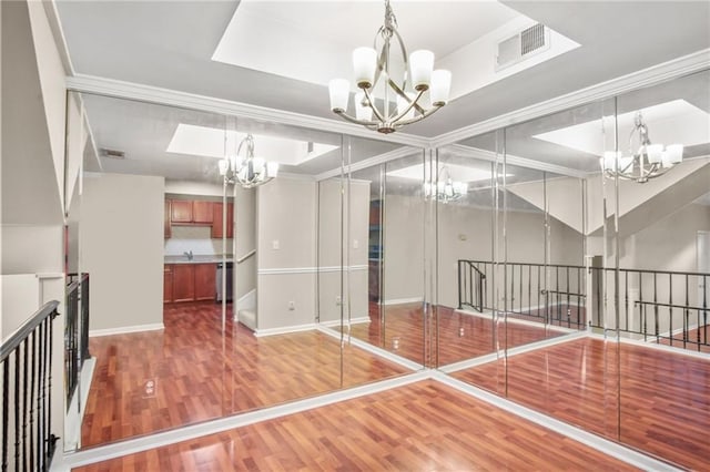 workout room with crown molding, a chandelier, sink, and wood-type flooring