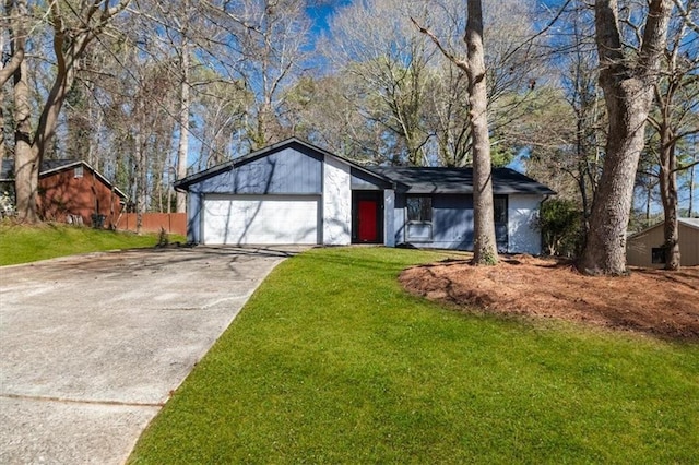 mid-century home with driveway, an attached garage, and a front yard