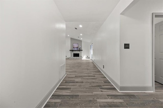 hall featuring wood tiled floor, baseboards, and recessed lighting