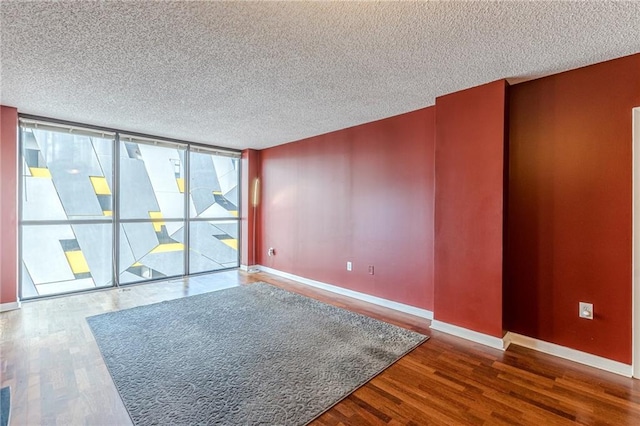 unfurnished room with hardwood / wood-style floors and a textured ceiling