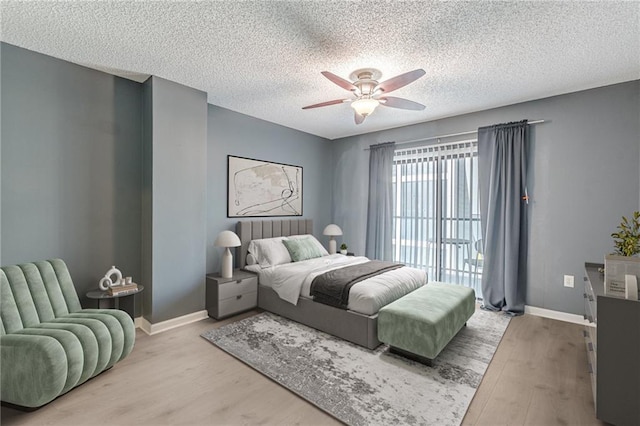 bedroom featuring ceiling fan, light wood-type flooring, and a textured ceiling