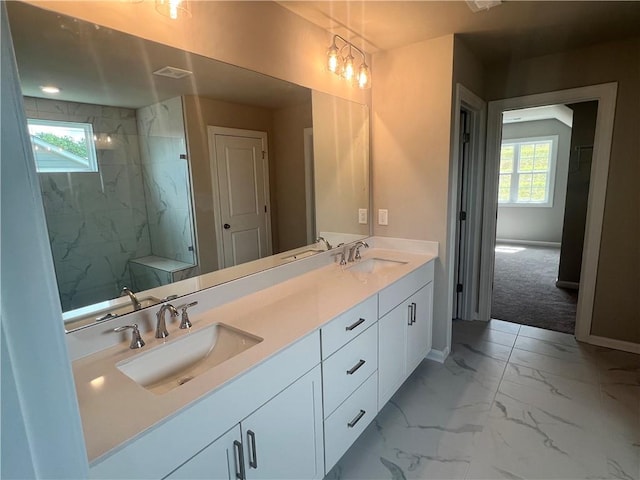 bathroom featuring a healthy amount of sunlight, a tile shower, and vanity