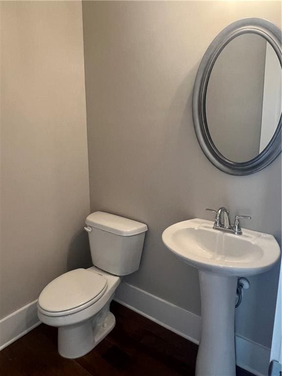 bathroom featuring wood-type flooring and toilet