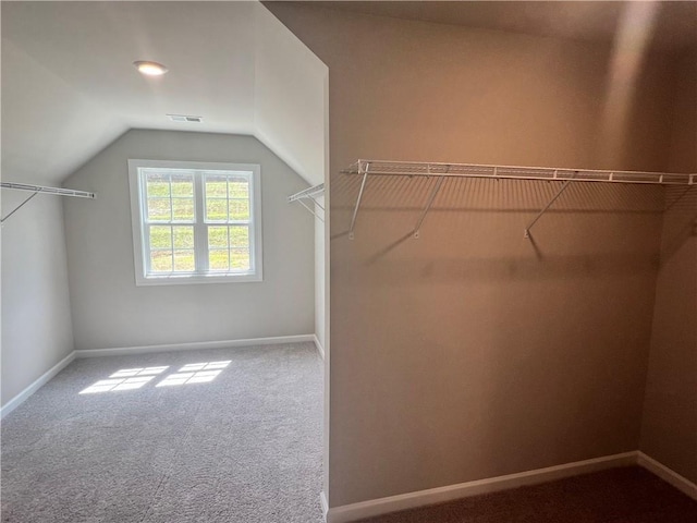 walk in closet with carpet and lofted ceiling