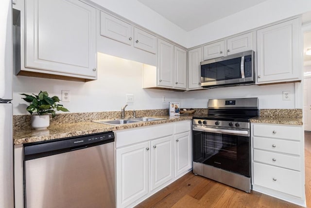 6 Stratford Hall Pl NE, Atlanta, GA 30342 - kitchen featuring appliances with stainless steel finishes, a sink, light wood-type flooring, and white cabinetry