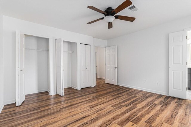 6 Stratford Hall Pl NE, Atlanta, GA 30342 - unfurnished bedroom with two closets, wood finished floors, baseboards, and ceiling fan