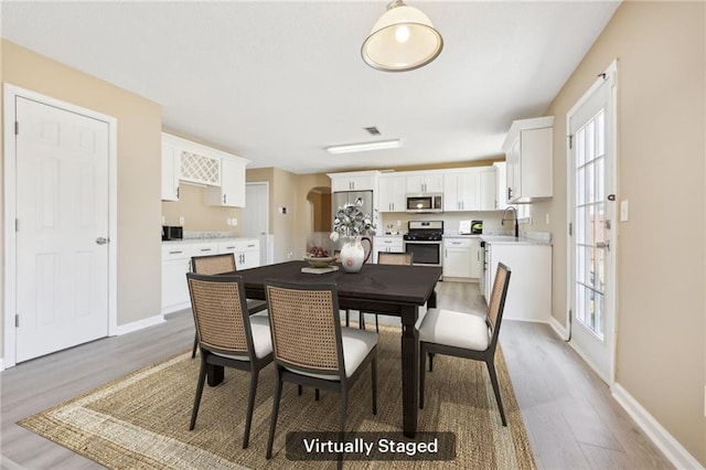 dining area with light wood finished floors and baseboards