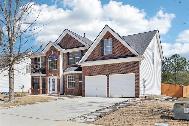 view of front of home with driveway, brick siding, and fence