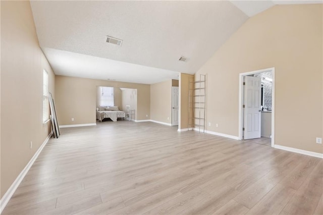 unfurnished living room with light wood finished floors, baseboards, and visible vents