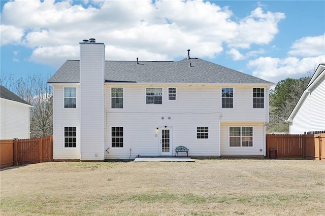 rear view of house featuring a fenced backyard, a chimney, a patio, and a yard