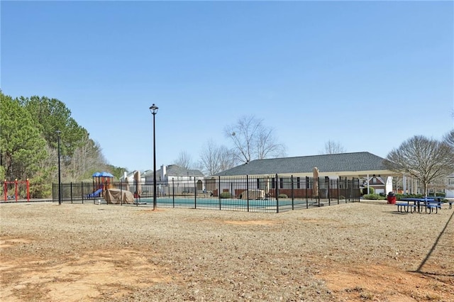 exterior space featuring playground community, a swimming pool, and fence