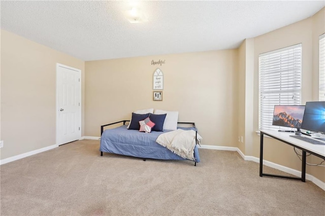 bedroom featuring a textured ceiling, carpet, and baseboards