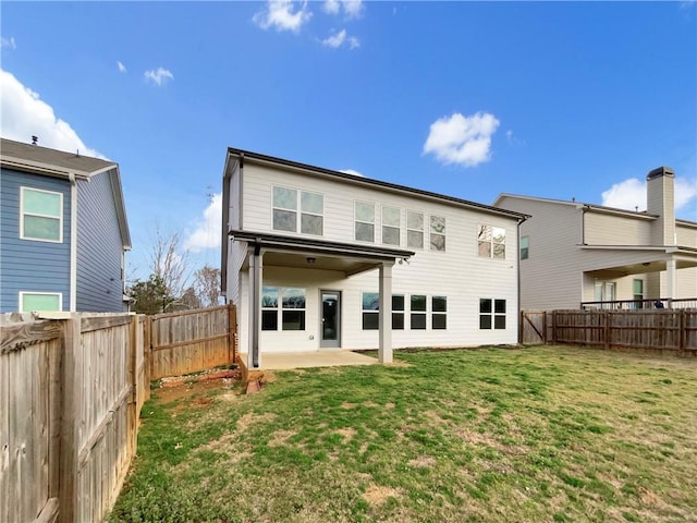 back of property featuring a fenced backyard, a yard, and a patio