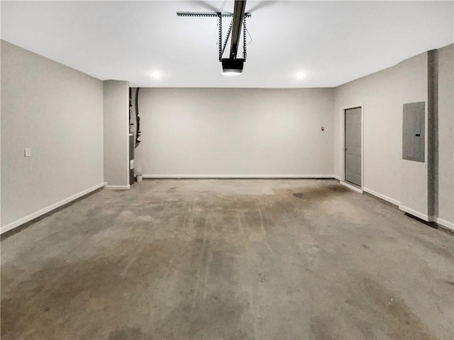 garage featuring a garage door opener, electric panel, and baseboards