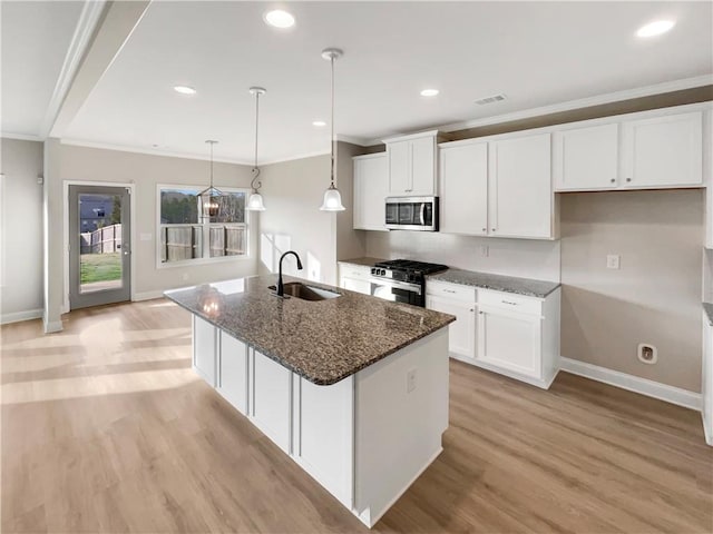 kitchen featuring stainless steel appliances, a sink, white cabinetry, and crown molding