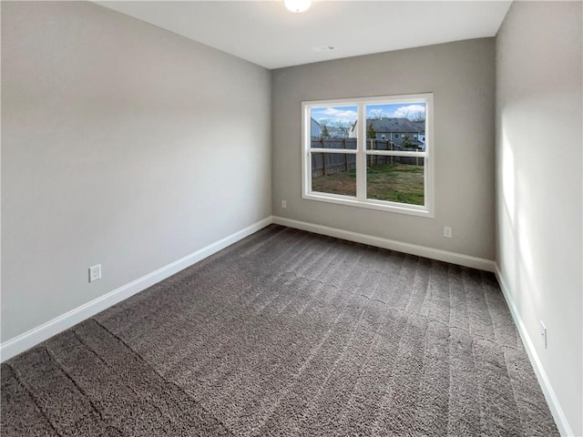 carpeted empty room featuring baseboards