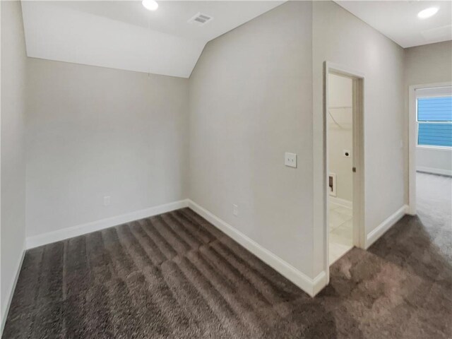 additional living space featuring carpet floors, visible vents, vaulted ceiling, and baseboards