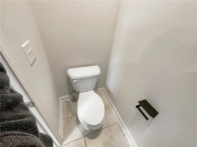 bathroom with tile patterned flooring, toilet, and baseboards