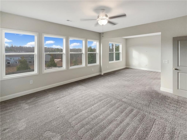 spare room with a ceiling fan, carpet, visible vents, and baseboards