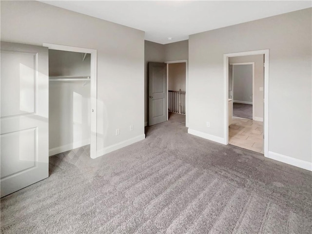 unfurnished bedroom featuring a closet, baseboards, and carpet flooring