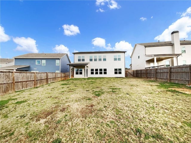 back of property featuring a fenced backyard and a yard