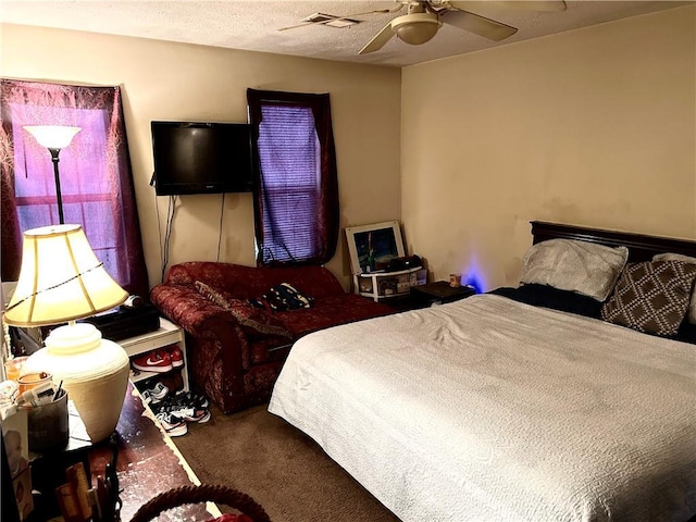 carpeted bedroom with a textured ceiling and ceiling fan