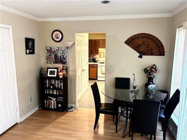 dining space featuring crown molding and light hardwood / wood-style floors