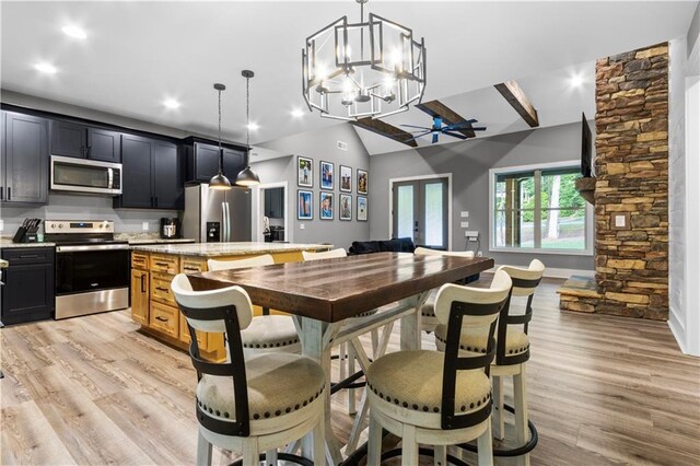 1441 Whitestone Rd, Talking Rock, GA 30175 - kitchen with appliances with stainless steel finishes, a kitchen island, lofted ceiling, a chandelier, and light wood finished floors