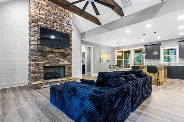 1441 Whitestone Rd, Talking Rock, GA 30175 - living room featuring light wood-style floors, a stone fireplace, baseboards, a ceiling fan, and beamed ceiling