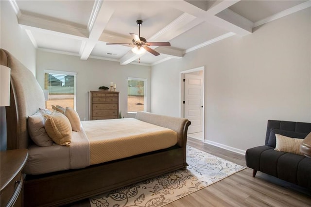 bedroom featuring multiple windows, coffered ceiling, wood finished floors, and beamed ceiling