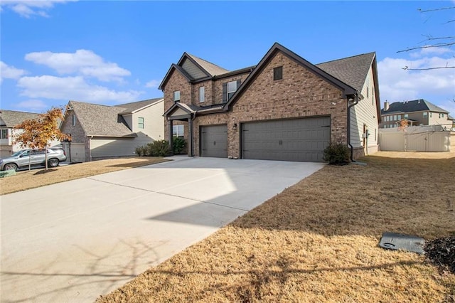 view of front of house featuring driveway, brick siding, an attached garage, and fence