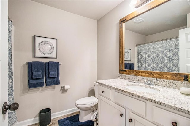 full bathroom with visible vents, toilet, vanity, wood finished floors, and baseboards