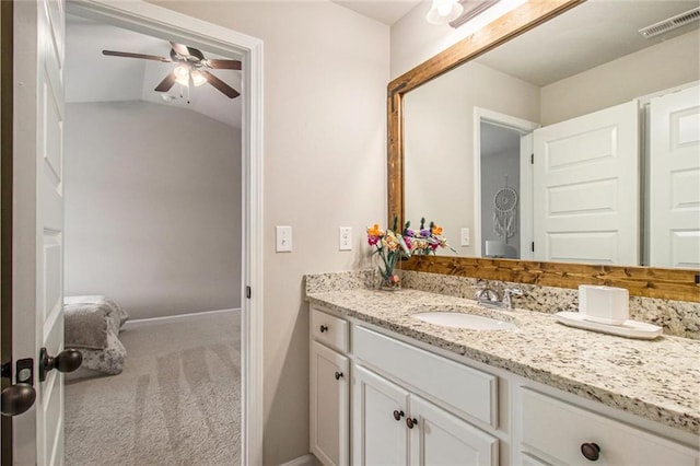 bathroom with baseboards, visible vents, lofted ceiling, ceiling fan, and vanity