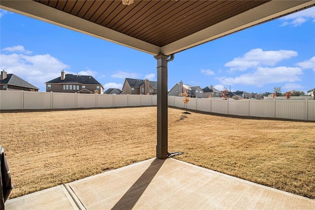 view of yard with a patio, a fenced backyard, and a residential view