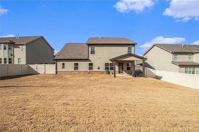 rear view of house with a patio and a fenced backyard